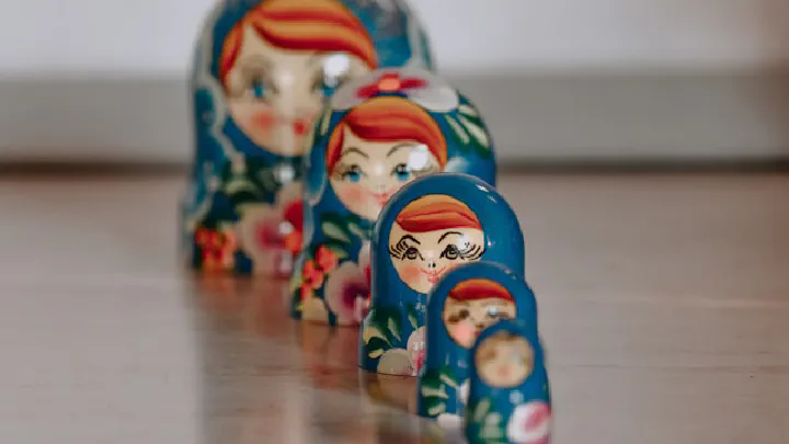 A row of colorful ceramic trinket figurines depicting stylized, cheerful female faces.